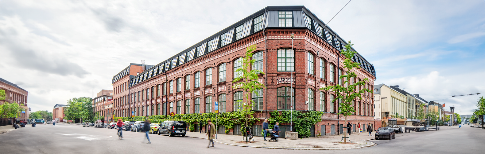 Image of a building and people walking in the street.