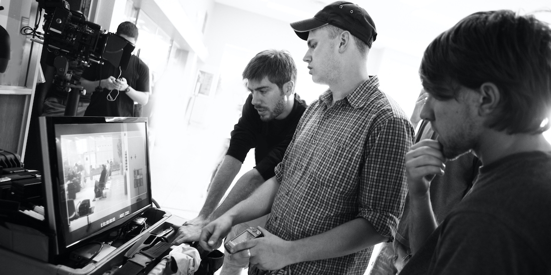 people working on a film in front of a computer