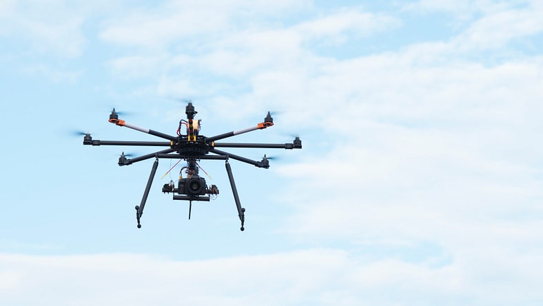 Drone in the air carrying professional camera