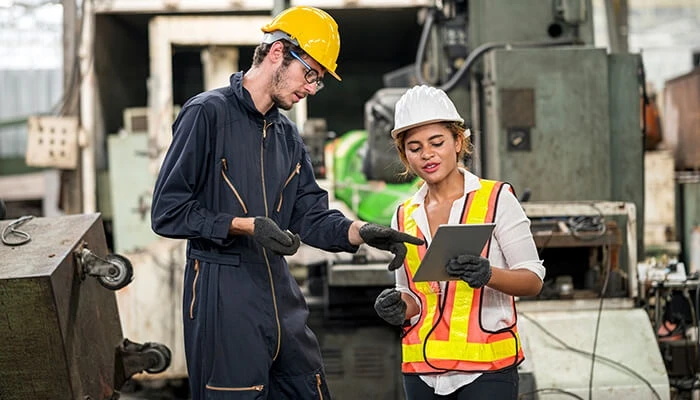 Workers in construction hats look at tablet