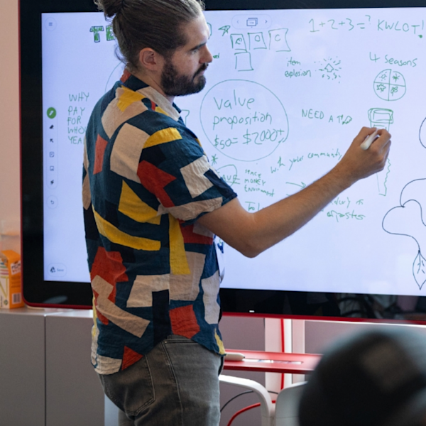 A creative director standing infront of a whiteboard writing out a strategic marketing plan