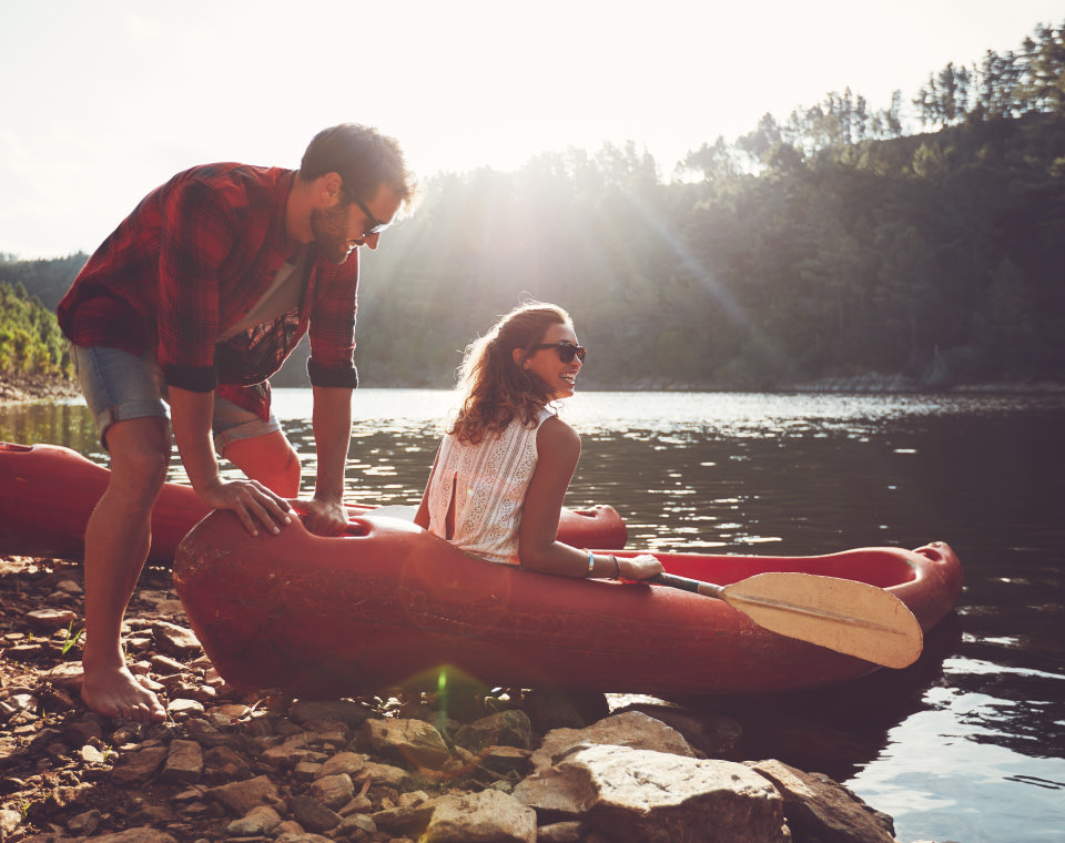 couple-laughing-as-they-prepare-to-canoe-i-screen