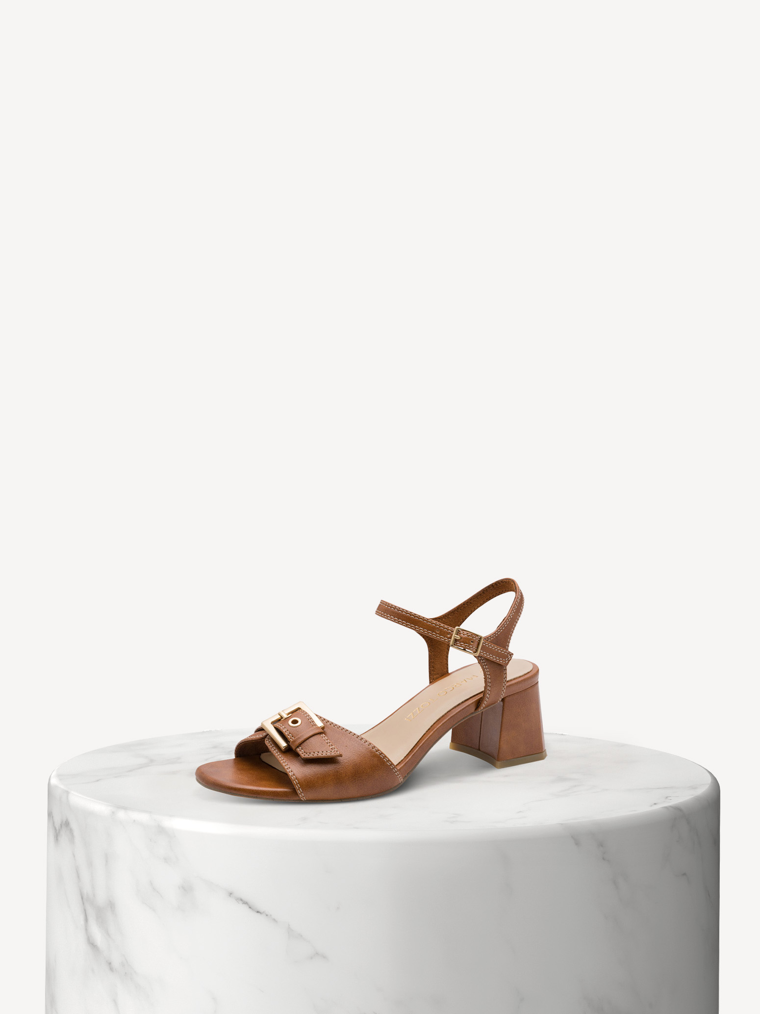Sandale beige à talon bloc et boucles colorées sur socle de marbre blanc sur fond clair