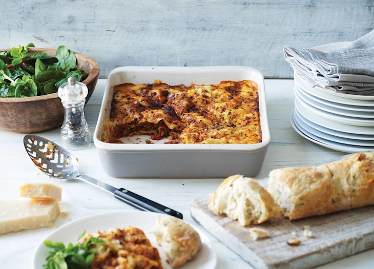 COOK lasagne served alongside garlic bread and salad