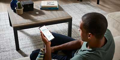 A picture of a man using the SmartThings app at home