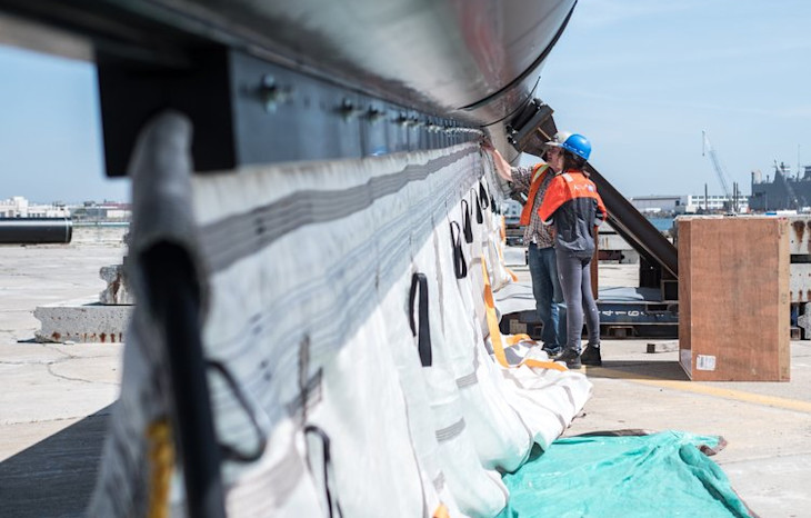 Some engineers inspecting a screen being installed on the Ocean Clean Up system