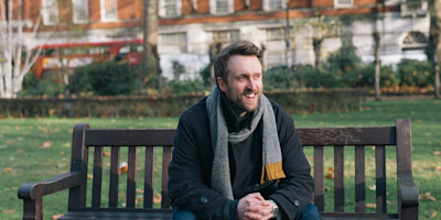Matt Winning sitting on a park bench.