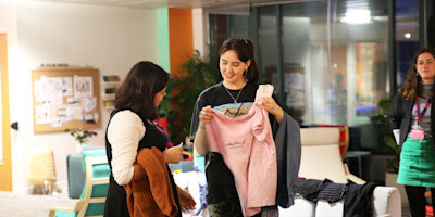 Two Bulb team members both eye up a pink jumper, hoping the other one will leave without it.