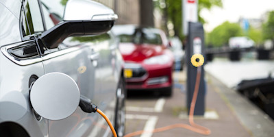 A photo of a an electric car at a charging station