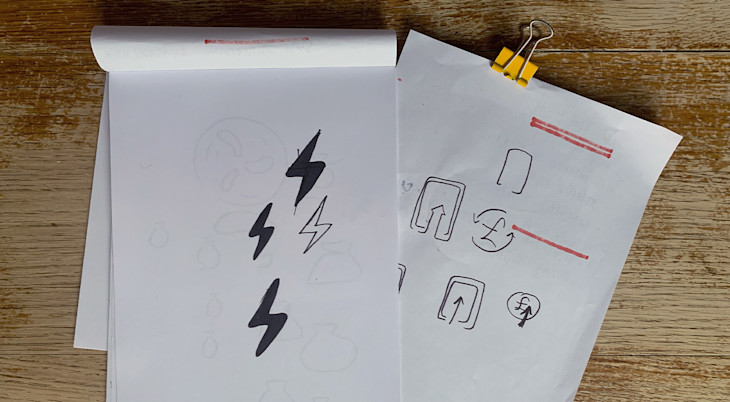 A sketchpad with some electric bolt icons doodled in pen