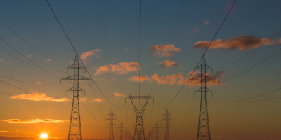 A picture of electricity poles at sunset