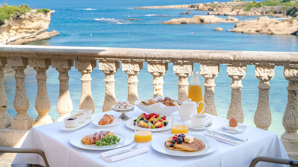 Dame spiser frukt ved bassengkanten. All inclusive med TUI