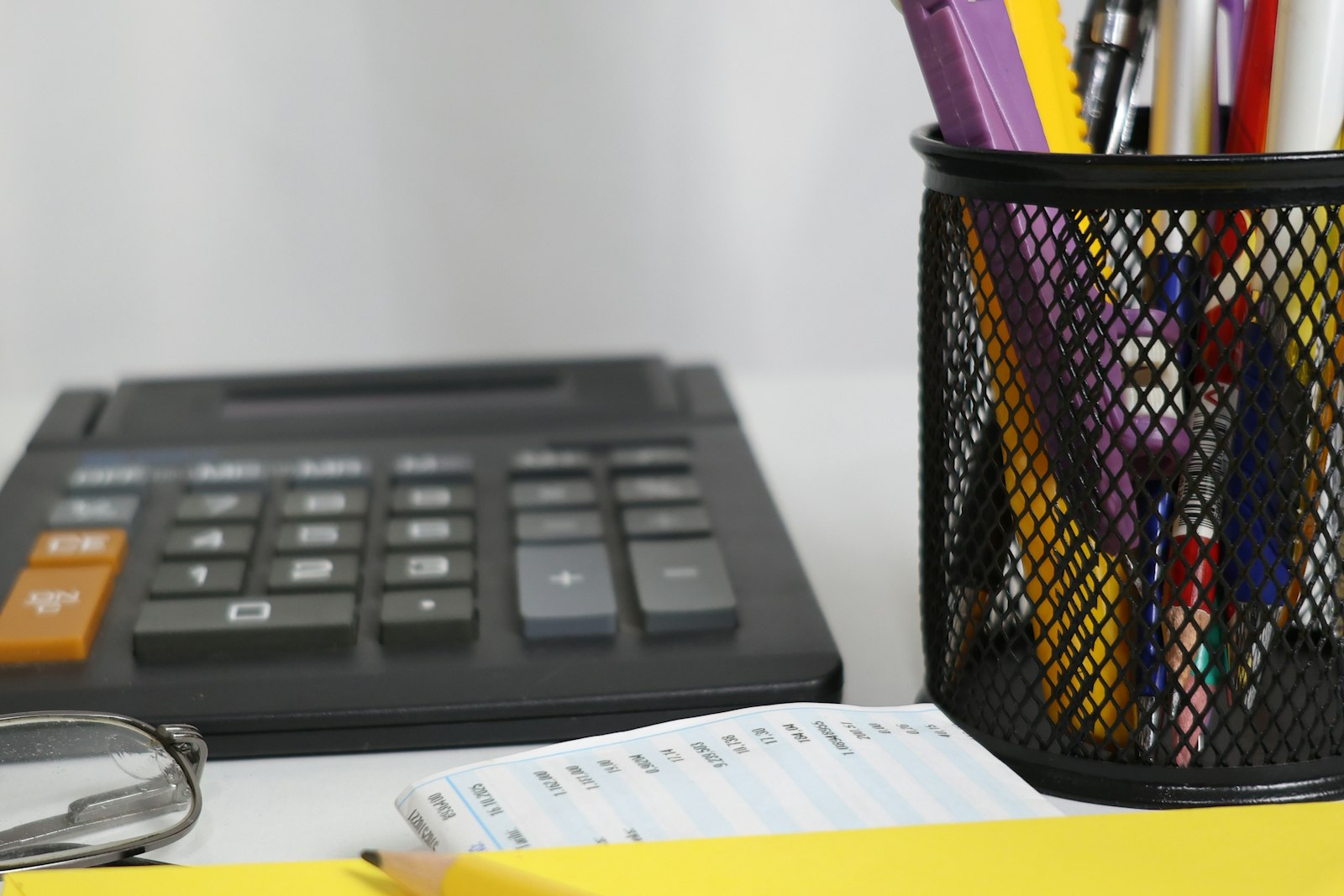 Calculator and pens on an office desk