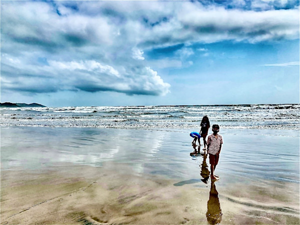 two children standing standing on a beach