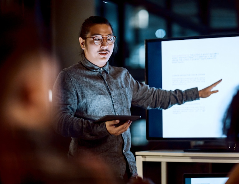 man explaining something pointing at a tv