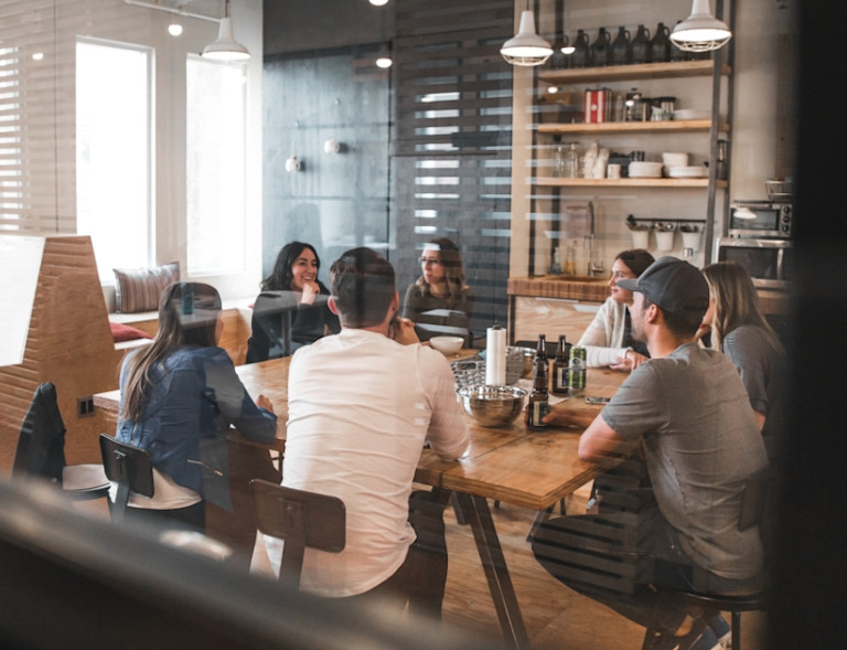 group of employees sitting around a table having drinks