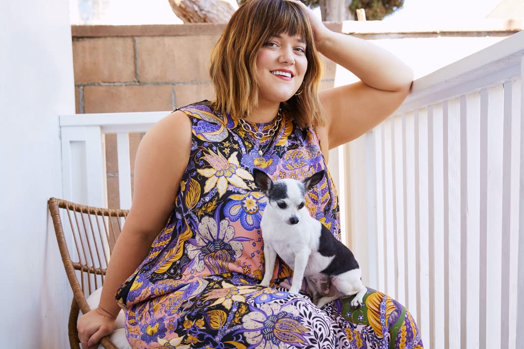 GIRL IN A DRESS WITH A DOG ON HER LAP.