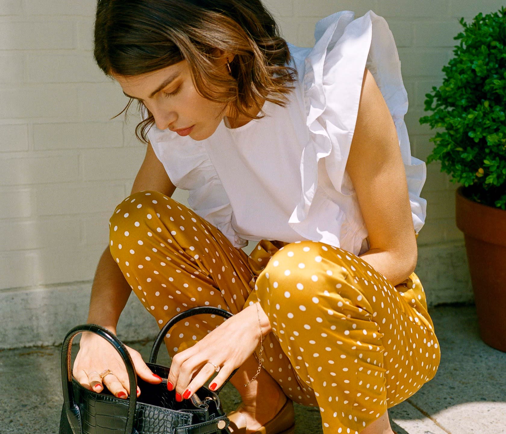 A white ruffled blouse and yellow polka dot trousers, taking you from work to cocktails.