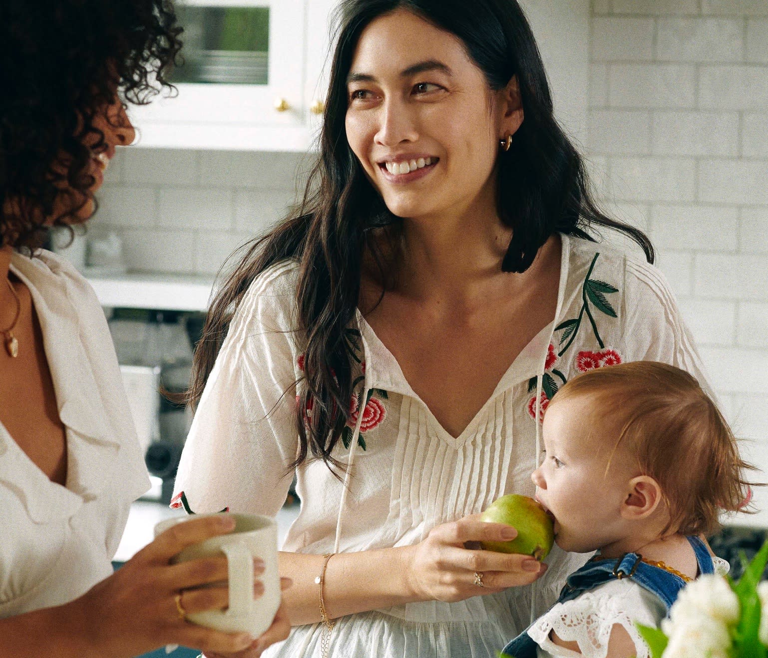 A mother with her child wearing a white blouse.