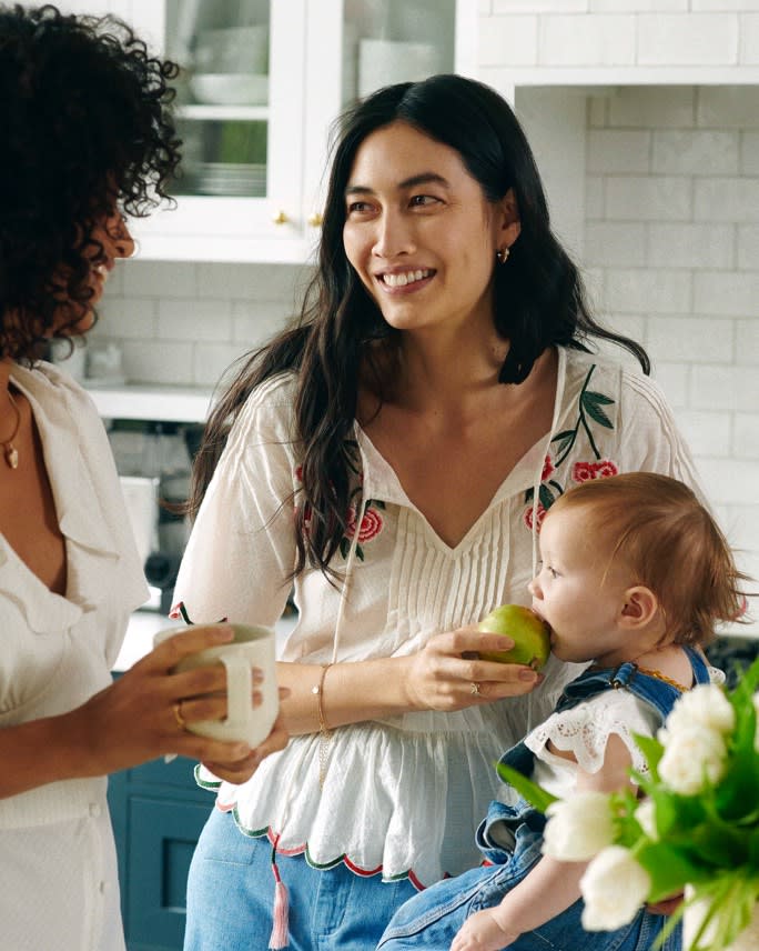 A mother with her child wearing a white blouse.