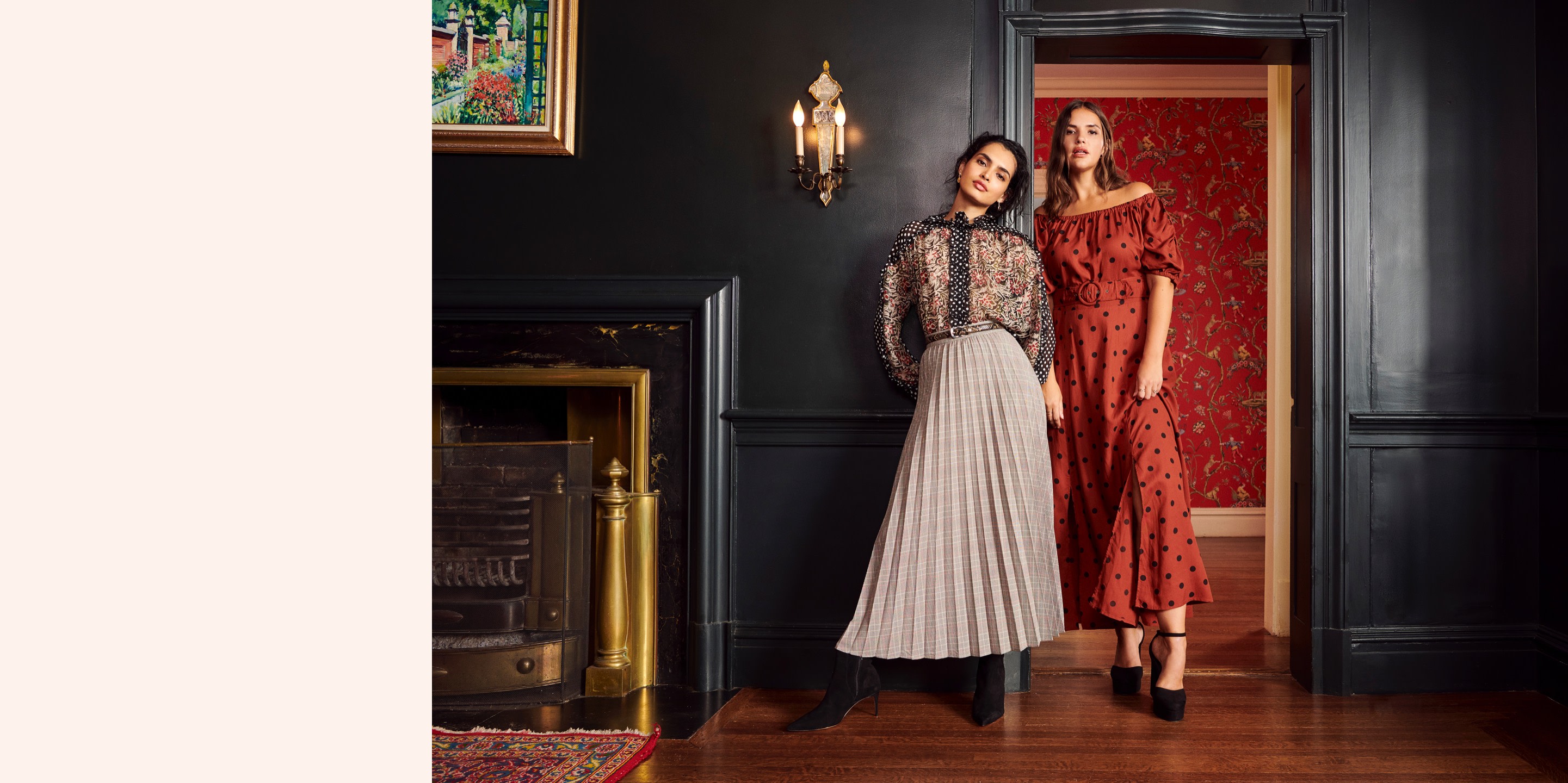 Models wearing mixed prints in a room with black walls and colorful wallpaper.