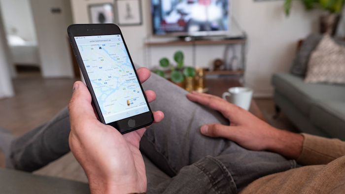 Man tittar på en mobil med en karta på skärmen