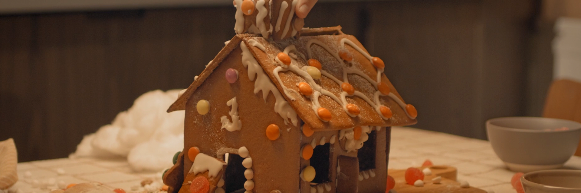 Pepparkakshus med kristyr och godis på taket
