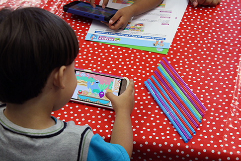 A young child uses the PBS kids app on a smart phone.