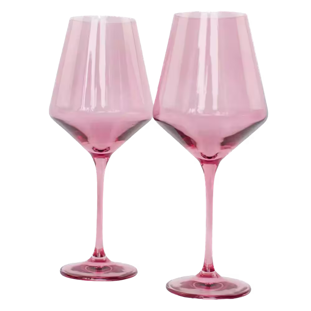 Two pink-tinted wine glasses with long stems, standing side by side against a plain background.