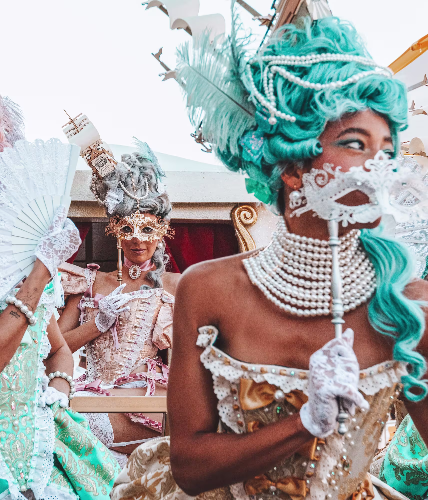 En O Beach Ibiza, la fiesta se llena de glamour con mujeres ataviadas con trajes de época, máscaras y plumas, creando un ambiente mágico y único.