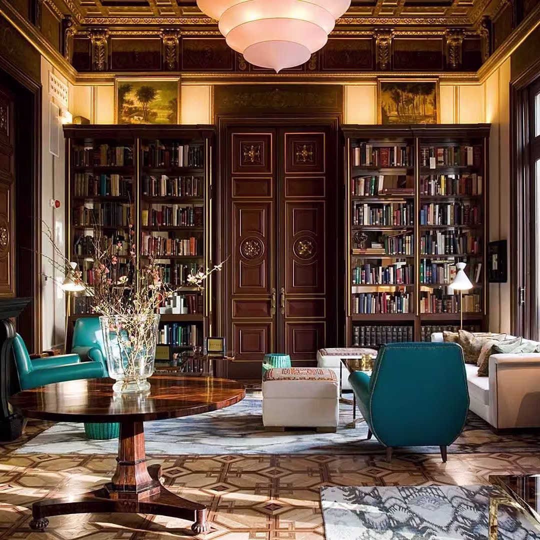 Una majestuosa biblioteca con detalles en madera noble, estanterías repletas de libros, asientos elegantes y una atmósfera acogedora en Cotton House.