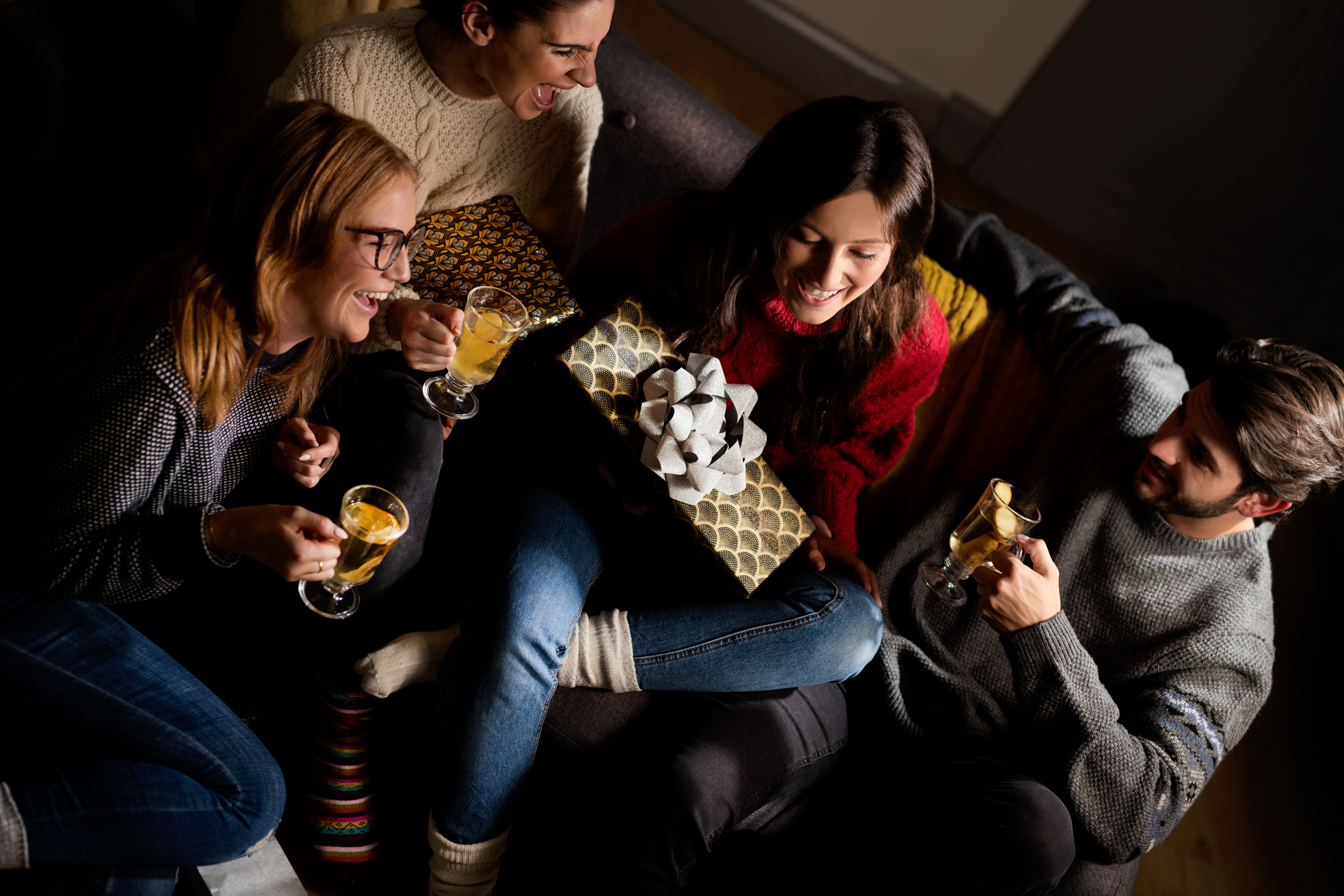 People drinking champagne in a group with Christmas presents