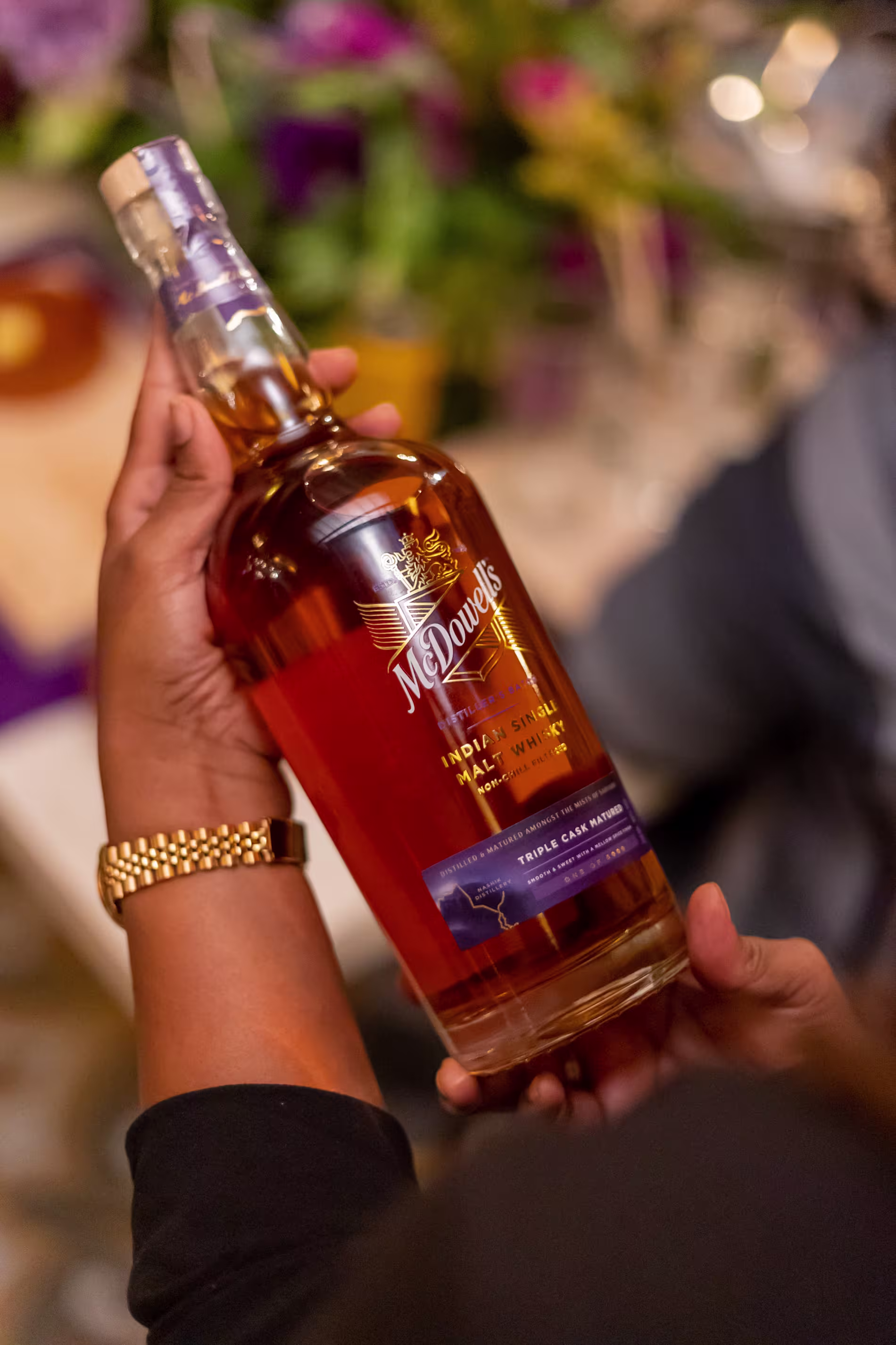 McDowells whisky bottle being held