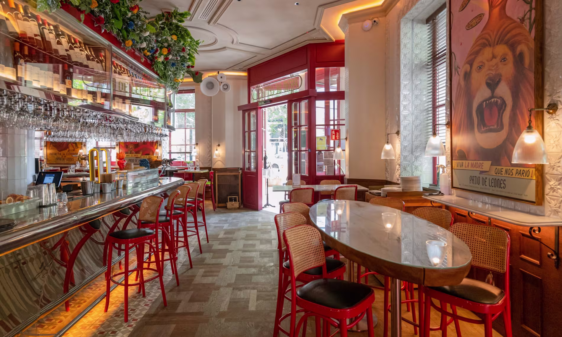 Interior de El Patio de Leones, con una barra clásica decorada con detalles florales, taburetes rojos con ambiente acogedor.