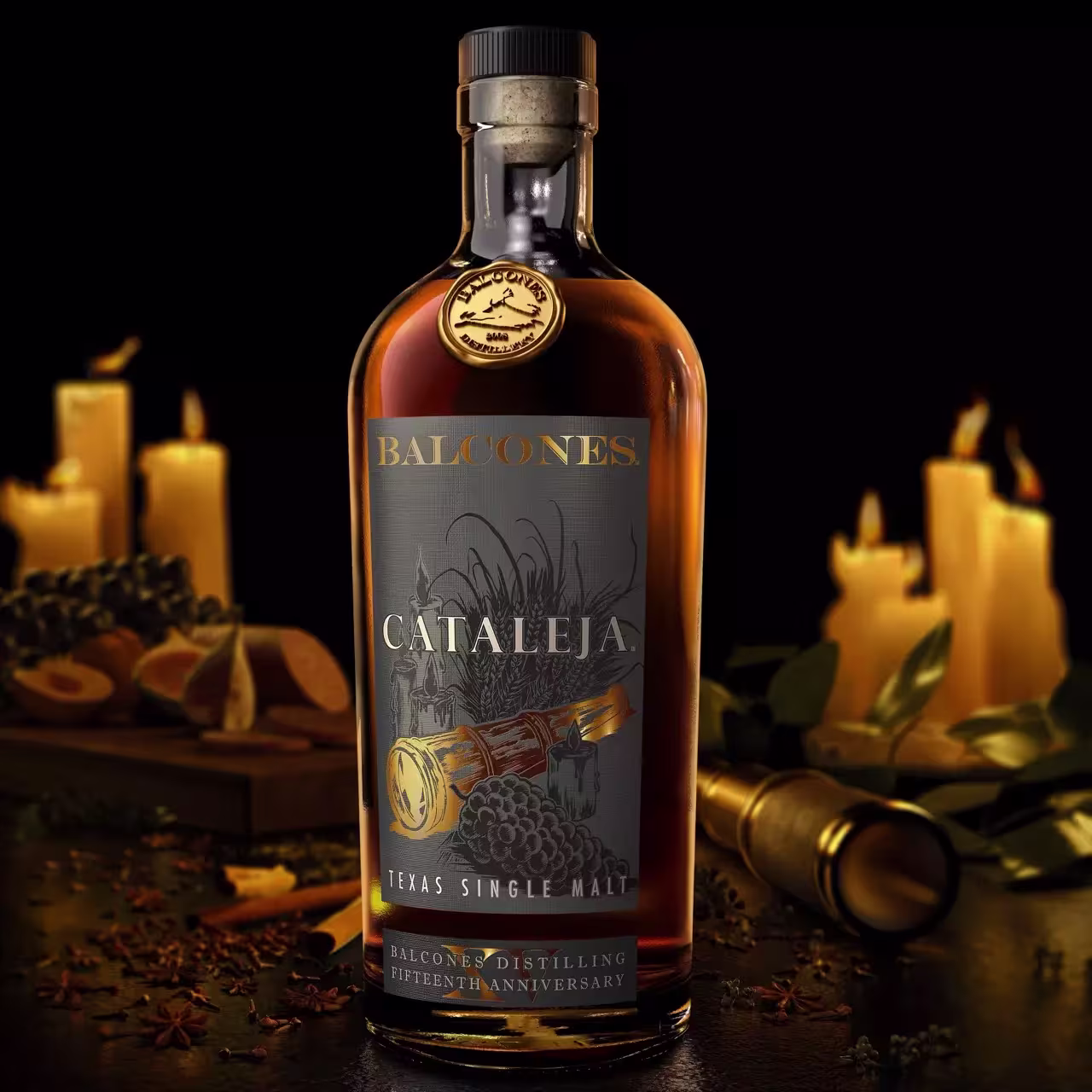 A bottle of Balcones Cataleja Texas Single Malt whiskey stands on a table with candles, dried citrus slices, spices, and a telescope in the background.