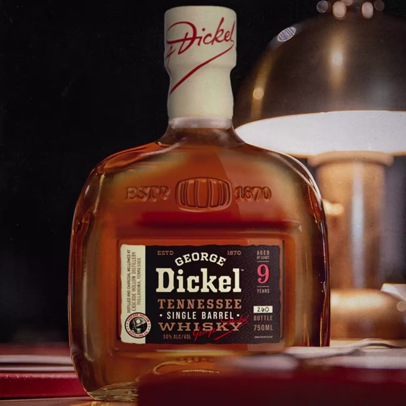 A bottle of George Dickel Tennessee Single Barrel Whisky, aged 9 years, 750ml, sits on a surface next to a lamp.