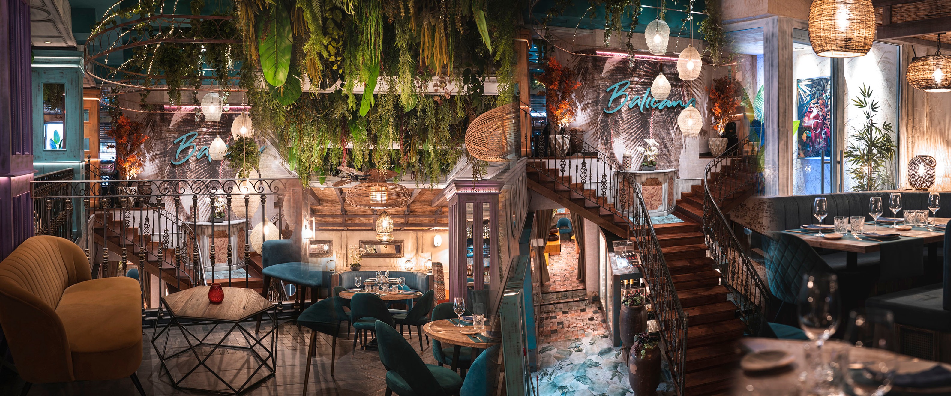 Restaurante Balicana con un diseño elegante y tropical, vegetación colgante, decoración sofisticada y una iluminación cálida con ambiente acogedor.