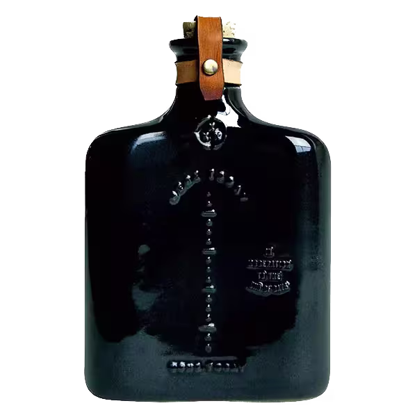 A dark, rectangular glass bottle with embossed text, a short neck, and a brown leather strap fastened with brass hardware around the top.