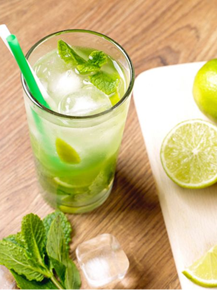 Refreshing non-alcoholic mojito garnished with lime wedges and mint, served with ice in a highball glass