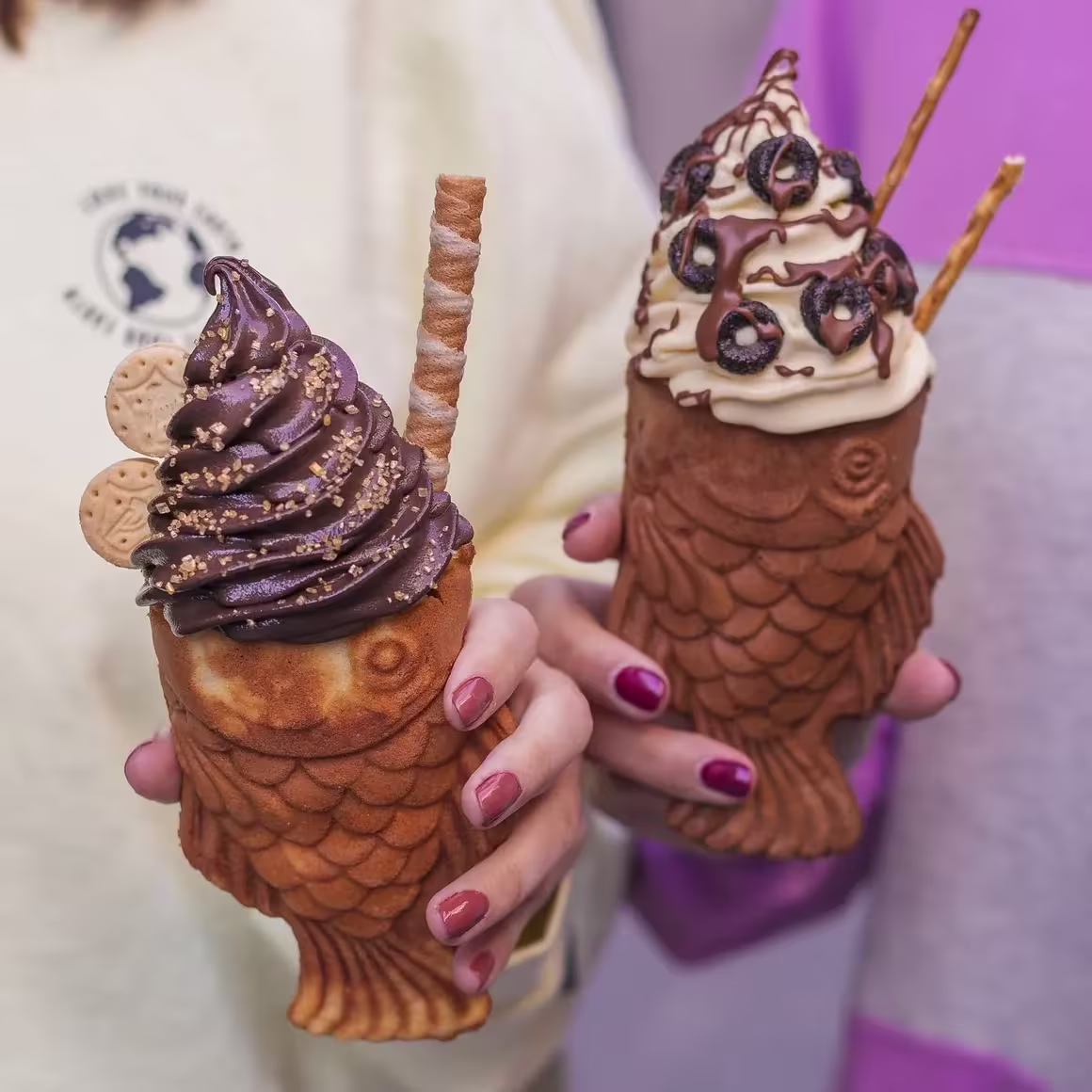 Helados en taiyakis de La Pecera, con cremosos toppings de chocolate, galletas y pretzels sobre gofres con forma de pez.