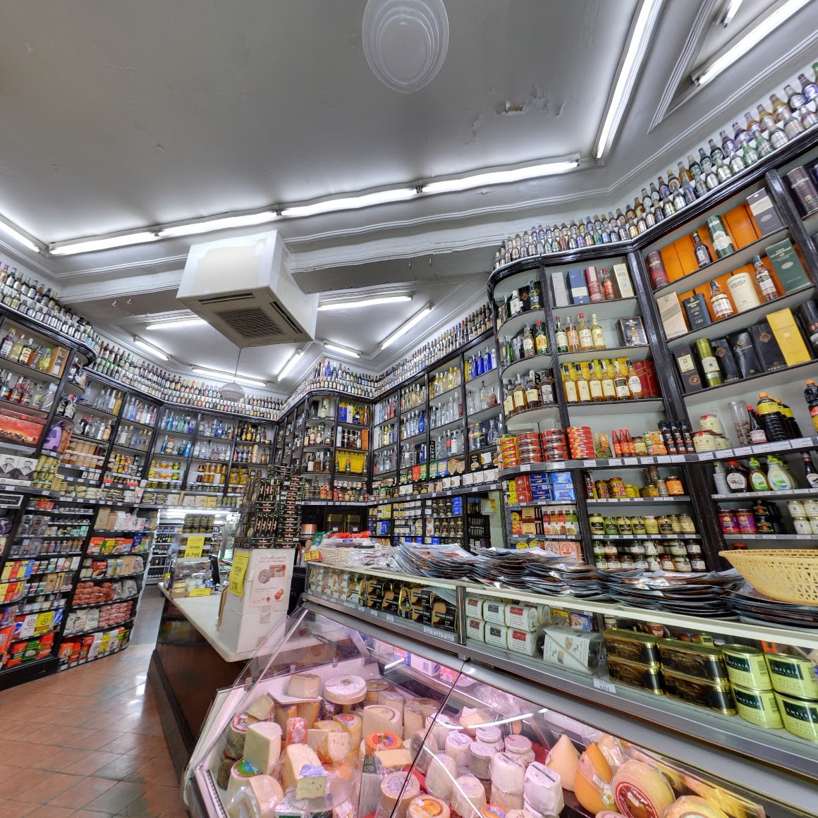 Colmado Quílez, una tienda tradicional de productos gourmet en Barcelona, con estanterías llenas de licores, conservas y una gran variedad de quesos.