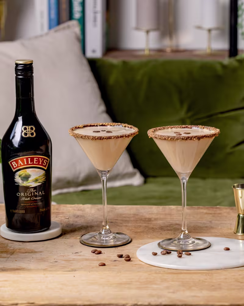 Două martini Baileys flat white cu garnitură de boabe de cafea.