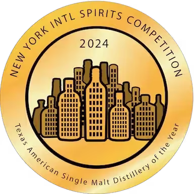 Circular gold badge for the 2024 New York International Spirits Competition, labeling Texas American Single Malt Distillery of the Year with bottle silhouettes in the center.