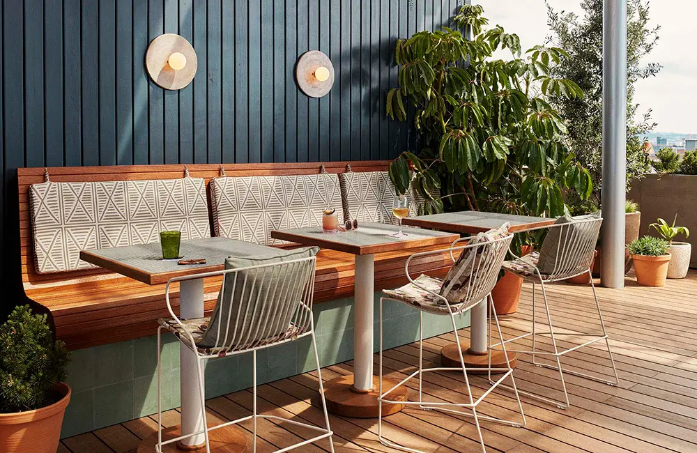 Tope en Hoxton Hotel ofrece una terraza acogedora con muebles modernos, decoración minimalista y vistas rodeadas de vegetación.