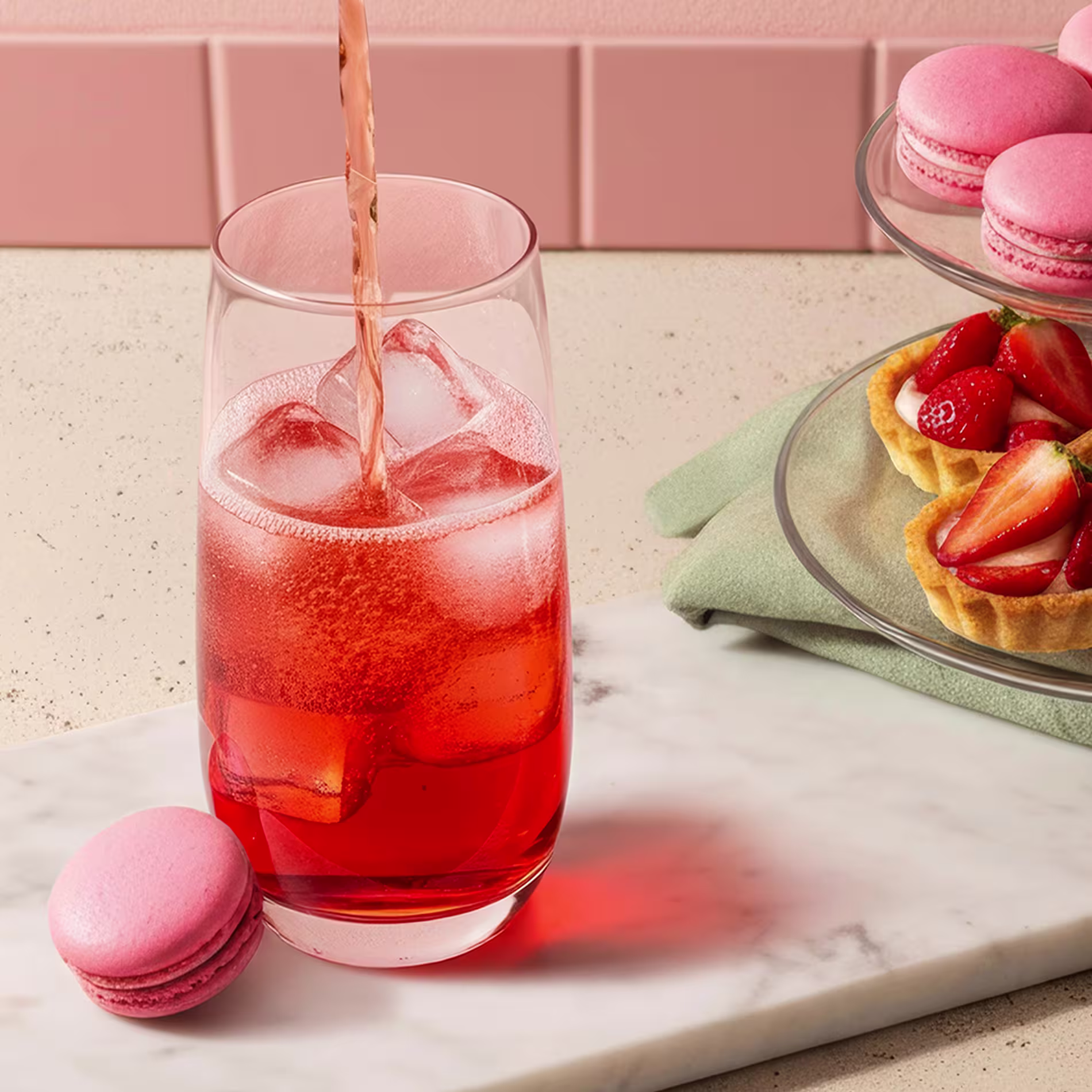 Ginger ale is poured into a pink Shirley Temple cocktail