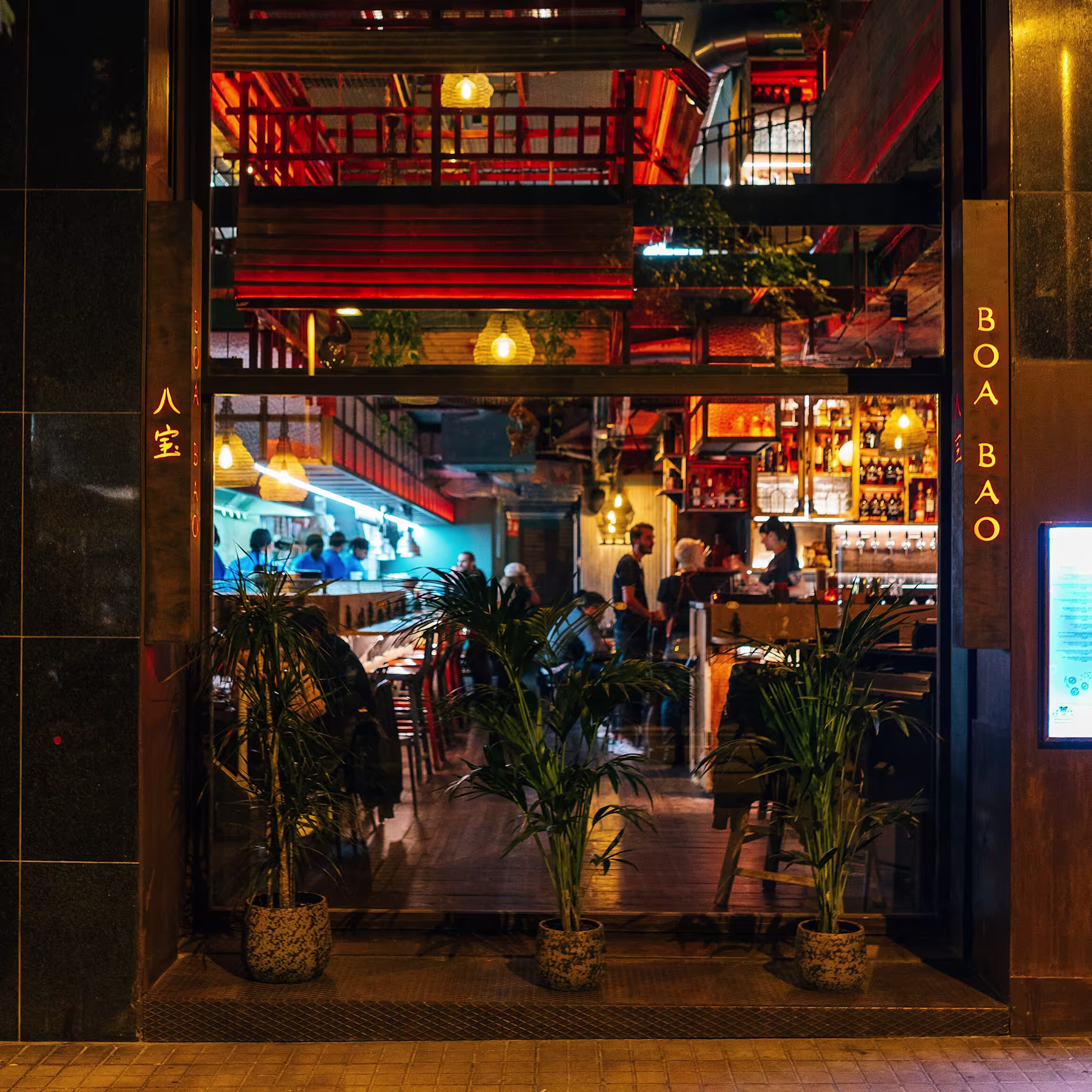 Fachada iluminada de Boa Bao, mostrando su vibrante interior con decoración asiática y un ambiente cálido y acogedor.