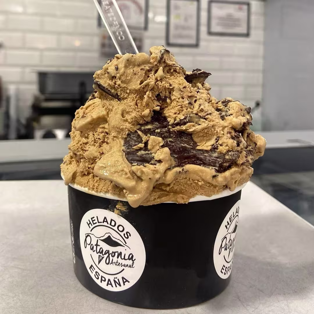 Copa de Helados Patagonia rebosante de dulce de leche y virutas de chocolate. Artesanía heladera servida con generosidad y sabor auténtico.