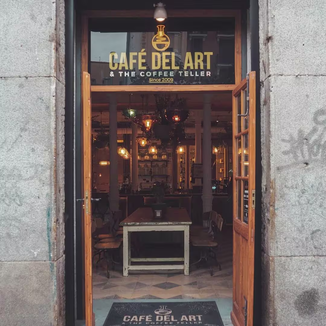 Café del Art fusiona elegancia y tradición con su ambiente bohemio y lámparas vintage, ideal para disfrutar de un buen café con encanto.