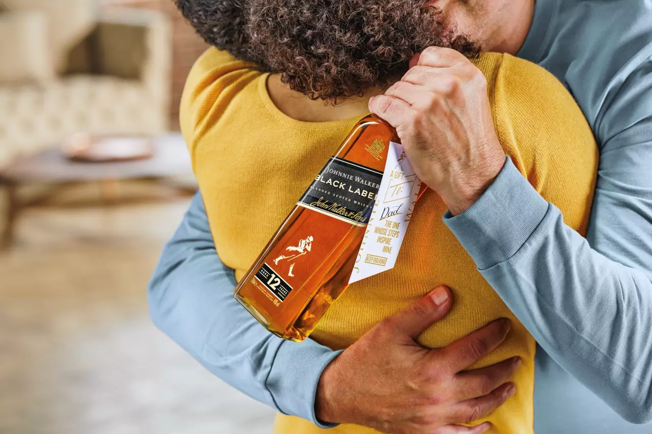 A person holding a bottle of Johnnie Walker Black Label whisky embraces another person wearing a yellow top.