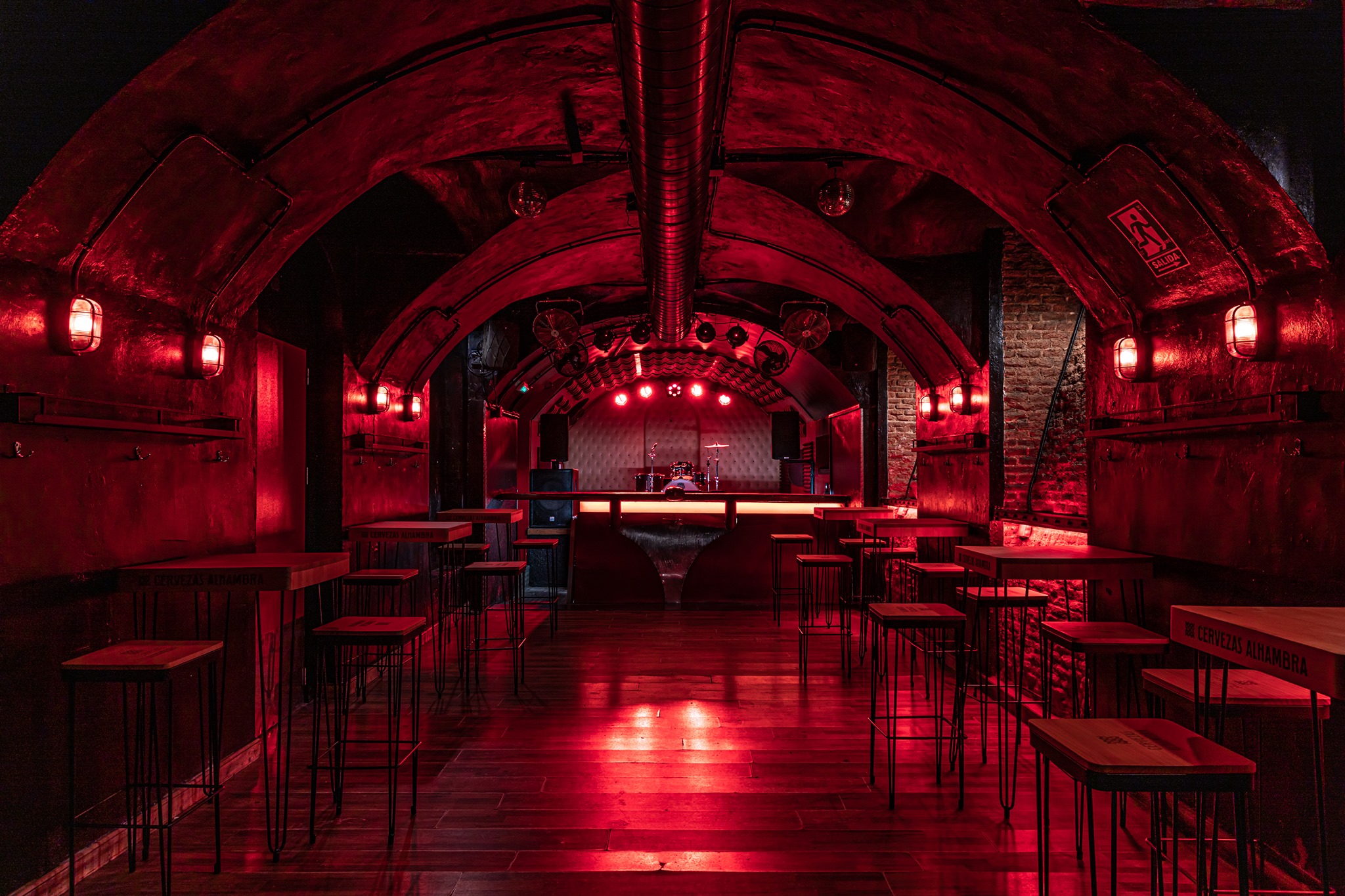 El Perro de la Parte de Atrás del Coche es un local subterráneo de estilo
industrial con luces rojas y un escenario para música en vivo